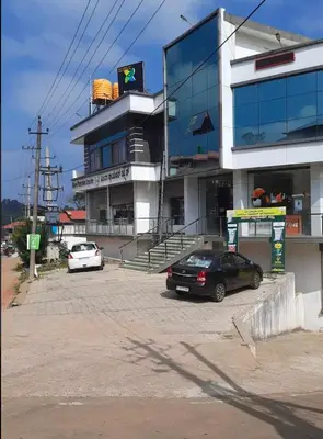 a black car parked in front of a building at Itsy Hotels Vijaya Comforts, With Bar & Restaurant in Madikeri