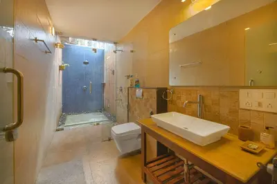 a bathroom with a sink and a toilet and a shower at StayVista at Tall Silver with Infinity Pool & Breakfast -2BR in Madikeri
