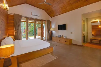 a large bedroom with a bed and a television at StayVista at Tall Silver with Infinity Pool & Breakfast -2BR in Madikeri