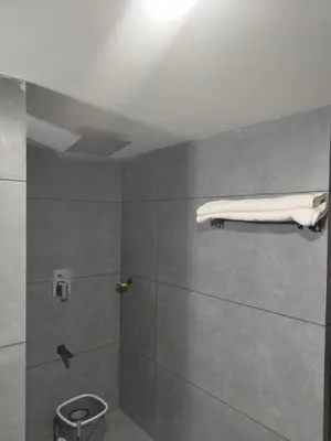 a bathroom with a shower with a mattress on the wall at Maleyam Homestay Riverside in Kozhikode
