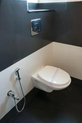 a bathroom with a white toilet in a stall at Comfort Hotels in Coimbatore