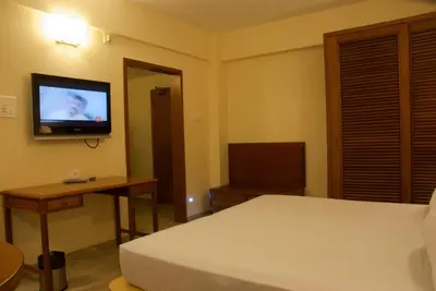 a bedroom with a bed and a television on the wall at Comfort Hotels in Coimbatore