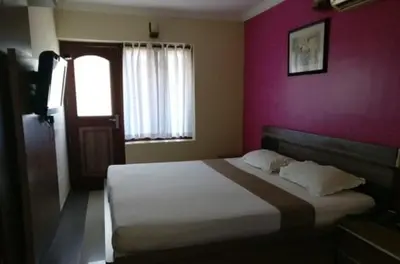 a bedroom with a large bed with a pink wall at French Avenue in Kallāyi