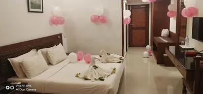 a bedroom with a bed with pink and white balloons at French Avenue in Kallāyi