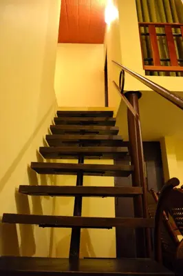 a set of stairs in a building with a railing at Kadkani River Resort Coorg in Siddapur