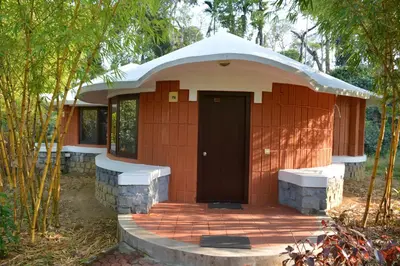 a small building with a door in the middle at Kadkani River Resort Coorg in Siddapur