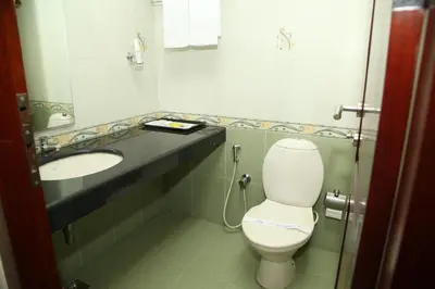a bathroom with a toilet and a sink at Kallada Residency in Kodungallūr