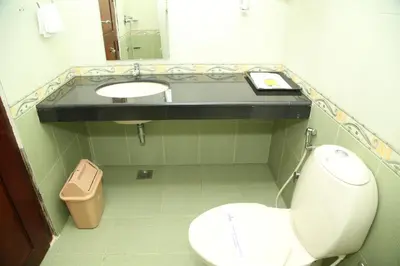 a bathroom with a white toilet and a sink at Kallada Residency in Kodungallūr