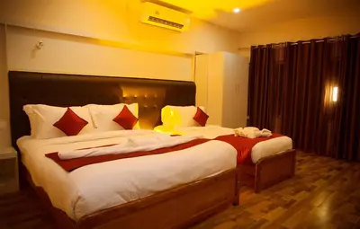 a bedroom with two beds in a room at Hotel Wayanad Square in Mananthavady