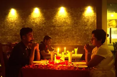 a group of people sitting around a table with candles at Hotel Wayanad Square in Mananthavady