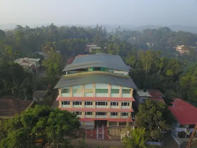 a large building with a roof on top of it at Hotel Wayanad Square in Mananthavady