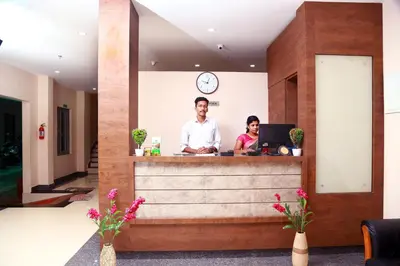 a man and a woman standing at a counter at Hotel Wayanad Square in Mananthavady