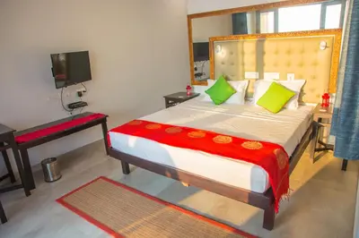 a bedroom with a bed and a desk and a television at 36 Palms Residency - Sea View Villa in Cochin
