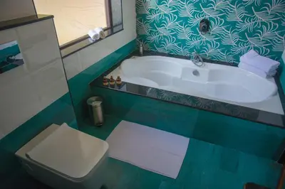 a bathroom with a bath tub and a toilet at 36 Palms Residency - Sea View Villa in Cochin