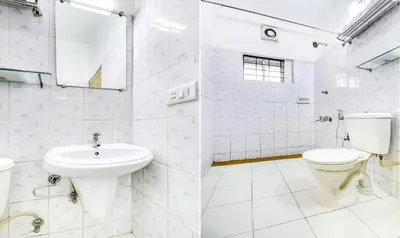 a white bathroom with a toilet and a sink at Itsy Hotels Ammu Regency in Trichūr