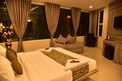 a hotel room with a large bed and a couch at Le Oak Inn in Mysore