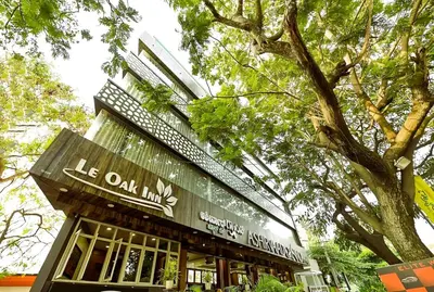 a building with a sign that reads he oak inn at Le Oak Inn in Mysore