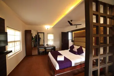 a hotel room with a bed and a desk at CONTOUR ISLAND RESORT & SPA , wayanad in Tariyod