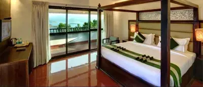 a bedroom with a large bed and a balcony at CONTOUR ISLAND RESORT & SPA , wayanad in Tariyod