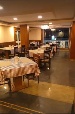 a dining room with tables and chairs and a restaurant at The Majestic Crown in Ooty