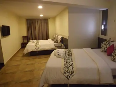a hotel room with two beds and a window at The Majestic Crown in Ooty