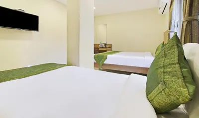 a hotel room with two beds and a flat screen tv at Itsy Hotels Jansi Residency in Coimbatore