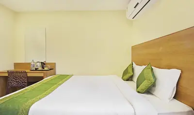 a bedroom with a bed and a desk with a table at Itsy Hotels Jansi Residency in Coimbatore