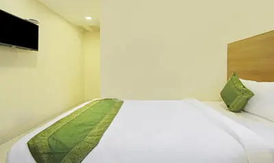 a white bed in a room with a television at Itsy Hotels Jansi Residency in Coimbatore