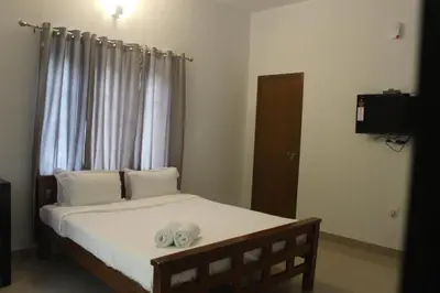 a bedroom with a bed with two towels on it at Zavon Holiday Home in Vythiri