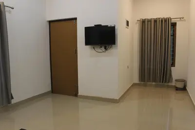 a room with a door and a television on the wall at Zavon Holiday Home in Vythiri