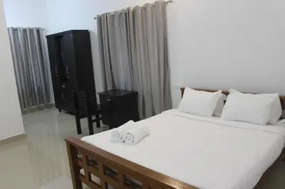 a bedroom with a bed with two towels on it at Zavon Holiday Home in Vythiri