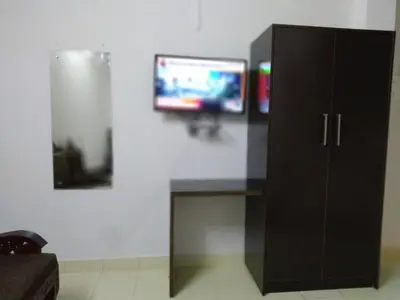 a black cabinet with a television on a wall at Apsara Residency in Perintalmanna