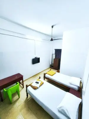 a room with two beds and a table at Apsara Residency in Perintalmanna