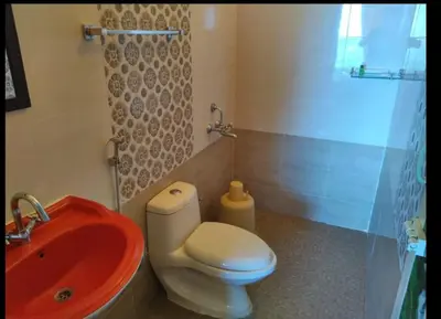 a bathroom with a red sink and a toilet at The Bowers Chalet Private Campfire & Lawn BBQ, WIFI, Breakfast Hill Top 360 degree view in Ooty
