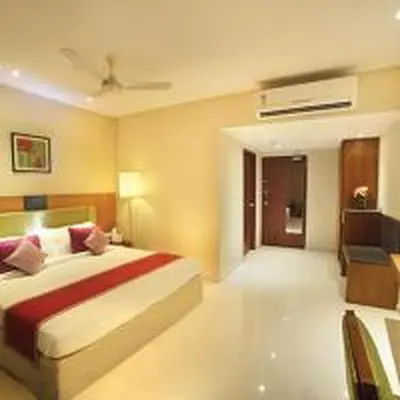a bedroom with a large bed with a red blanket at Jk Park Residency Perambra in Mennānyam