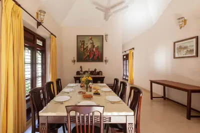 a dining room with a long table and chairs at Crystal Homestay by StayVista - 4BR in Madikeri
