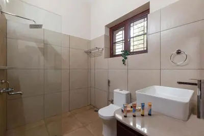 a bathroom with a toilet and a sink and a shower at Crystal Homestay by StayVista - 4BR in Madikeri