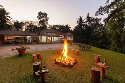 a fire in the yard of a house at Crystal Homestay by StayVista - 4BR in Madikeri