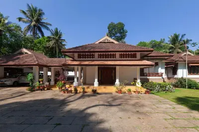 a house with a pavilion with chairs in front of it at Crystal Homestay by StayVista - 4BR in Madikeri