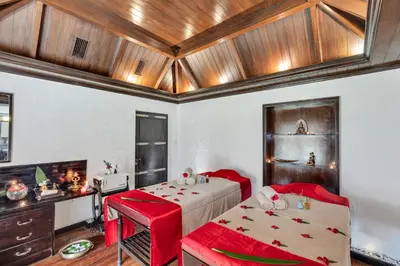 a bedroom with a bed and two red chairs at Club Mahindra Derby Green, Ooty in Ooty