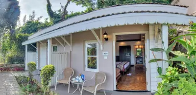 a small cottage with an arbor over the door at Club Mahindra Derby Green, Ooty in Ooty