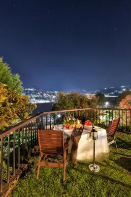 a dinner table on a balcony at night at Club Mahindra Derby Green, Ooty in Ooty