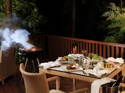a table with food and a grill on a deck at The Tamara Coorg in Kakkabe