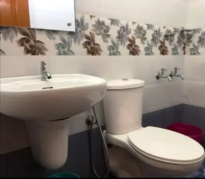 a bathroom with a white toilet and a sink at Jippus Galaxy Budget Air port hotel in Cochin