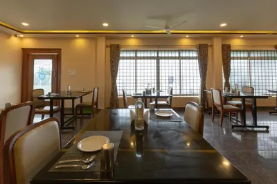 a dining room with a long table and chairs at KSTDC Hotel Mayura Biligiri, BR Hills in Honganūr