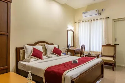a bedroom with a large bed with a red blanket at KSTDC Hotel Mayura Biligiri, BR Hills in Honganūr