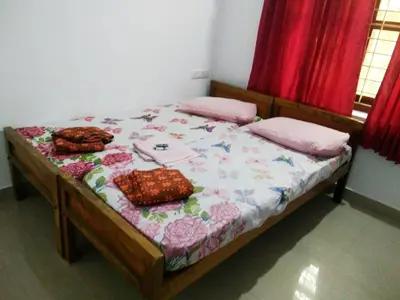 a bed with two pillows and a blanket on it at Nunu Homestay Guruvayoor in Guruvāyūr