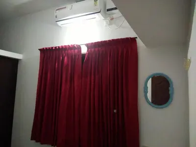 a room with a red curtain and a mirror at Nunu Homestay Guruvayoor in Guruvāyūr
