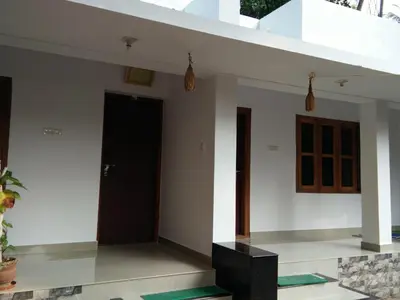a room with a black door and white walls at Nunu Homestay Guruvayoor in Guruvāyūr
