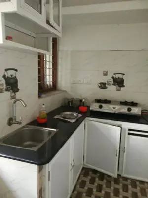 a kitchen with a sink and a stove at Nunu Homestay Guruvayoor in Guruvāyūr
